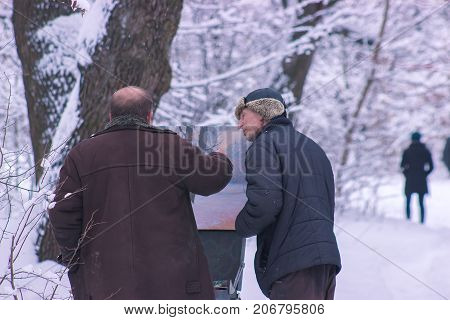 Zhytomyr Ukraine - December 12 2016: Street artist draws the picture standing in street park of passersby