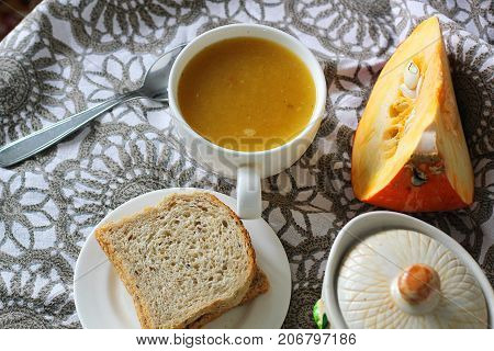 Pumpkin soup in white mug on table. Modern photography. The best for book with recipies.