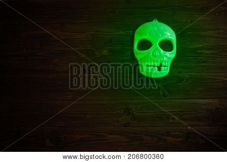 Halloween Glowing Phosphoric Human Skull Over Wooden Table Background. Neon Light