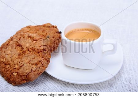 Classic espresso in white cup with cake on white background