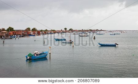 Porto Tolle, Rovigo, Veneto, Italy: marine landscape of the Adriatic sea coast in the Po Delta Park with fishing boats and the fishermen's huts