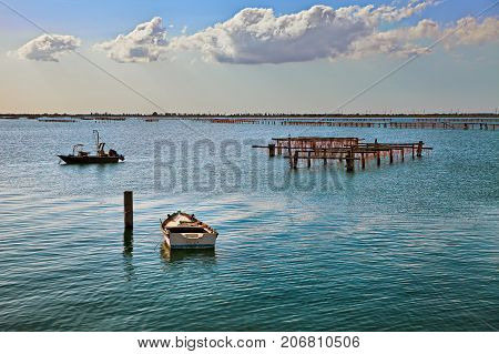 Porto Tolle, Rovigo, Veneto, Italy: marine landscape of the Adriatic sea in the Po Delta Park with fishing boats and wooden poles for mussels farming
