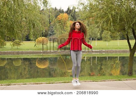 A Fit And Athletic Young Woman Is Skipping With A Jump Rope In The Park