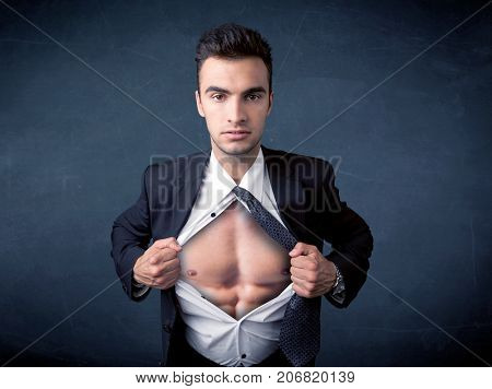Businessman tearing off his shirt and showing mucular body concept on background
