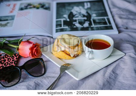 bun with cinnamon and kremoi on a pink plate in a romantic setting with roses