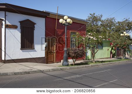 Pica, Tarapaca, Chile - August 28, 2017: Colourful buildings along a tree lined street in the small village of Pica in the Atacama Desert, Tarapaca, Chile.