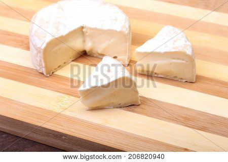 Cheese with white mold. Camembert or brie type on wood table. Healthy breakfast