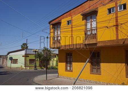 Pica, Tarapaca, Chile - August 28, 2017: Colourful buildings along a tree lined street in the small village of Pica in the Atacama Desert, Tarapaca, Chile.