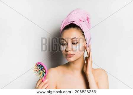 lovely girl after a shower looks in a colorful mirror