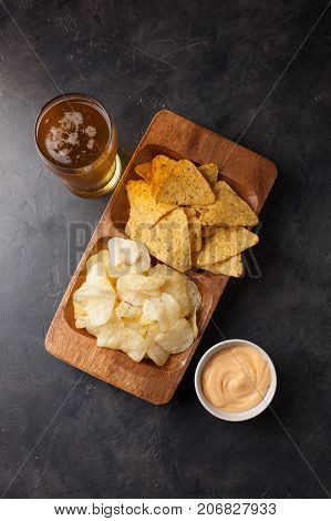 Beer In Glasses Closeup On The Concrete Table. Beer And Snacks Are Chips And Nachos With Cheese Souc