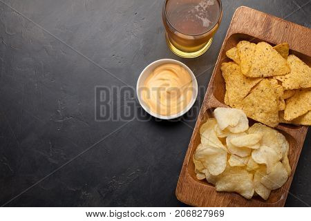 Beer In Glasses Closeup On The Concrete Table. Beer And Snacks Are Chips And Nachos In Wooden Bowl W