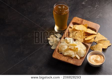 Beer In Glasses Closeup On The Concrete Table. Beer And Snacks Are Chips And Nachos In Wooden Bowl W
