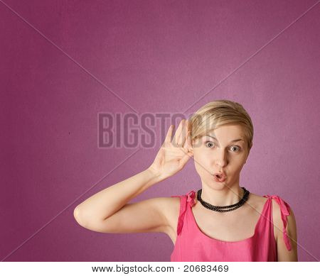 femmina overhearing qualcosa con il suo orecchio e mano