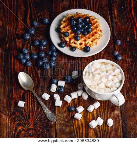 Waffles with Fresh Blueberry and Honey on Plate Cup of Coffee with Marshmallow.