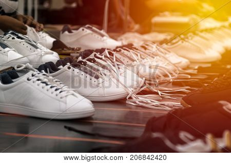 worker working on lacing process in footwear factory workshop