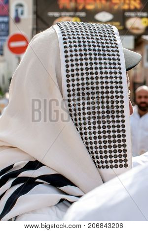 Orthodox hassidic Jew pray in a holiday robe and tallith.