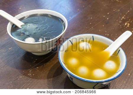 Close-up view of Chinese desserts including rice dumplings and black sesame soup