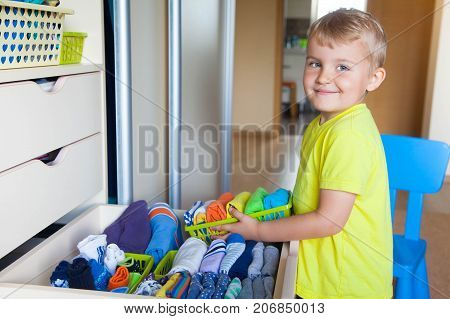 The Child Puts His Clothes On. The Boy Pulls The T-shirt Out Of The Closet.