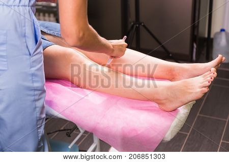 Hair removal cosmetology procedure from a therapist at cosmetic beauty spa clinic. Laser epilation and cosmetology