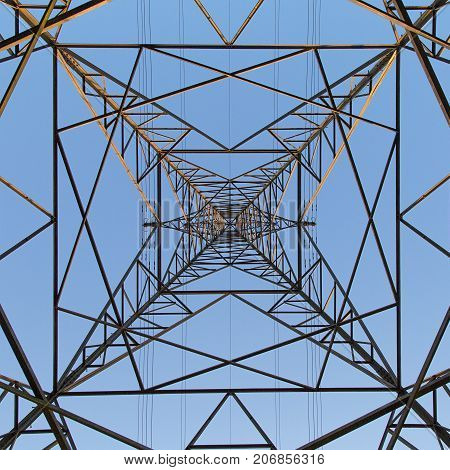 Dramatic angle perspective looking up at an electricity pylon from directly below in a square format