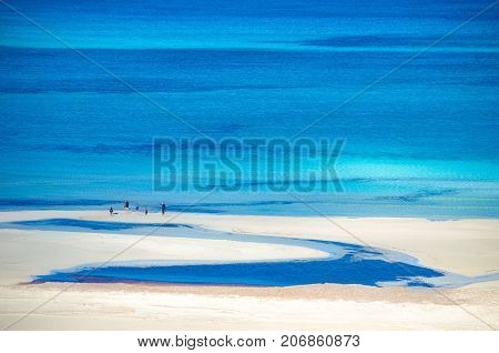 View of the amazing beach of Balos, with a family playing on the tropical sandy beach with turquoise waters, Crete, Greece