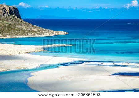View of the amazing beach of Balos, with a family playing on the tropical sandy beach with turquoise waters, Crete, Greece