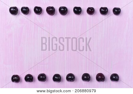 composition of ripe sweet cherry on a pink background