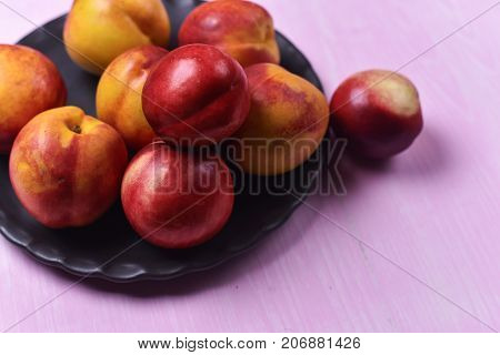 composition of ripe peaches on a pink background