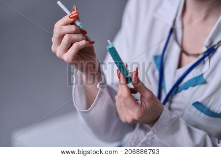The syringe with the medicine in the doctor's arms