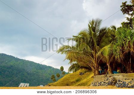 Beautiful Beach With Granite Rocks And Palm Trees On A Cloudy Day On Sunset