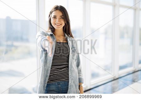 Pretty Woman Shaking Hands Against Panoramic Window