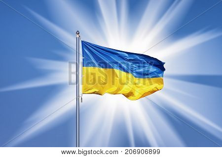 Ukrainian flag on blue sky backgroud snd big sun