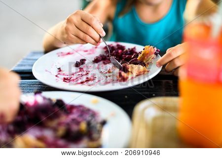 Children Eating Blueberry Strudel With Sugar On Top.