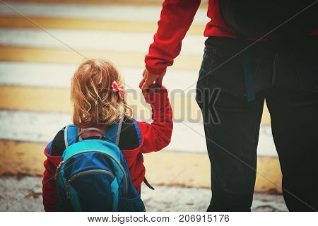 mother walking little daughter to daycare, education concept