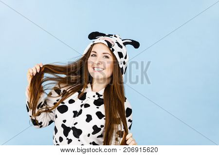 Happy teenage girl in funny nightclothes pajamas cartoon style smiling positive face expression studio shot on blue.