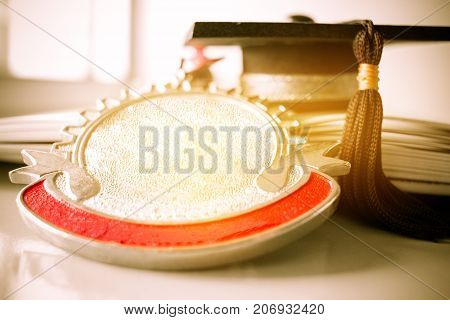 Graduation cap and golden medals on book graduate education in university Competitions and Education study concepts. Success in study famous institution Concept of winner abroad international.