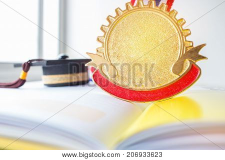 Golden medals and Graduation cap on book graduate education in university Competitions and Education study concepts. Success in study famous institution Concept of winner abroad international