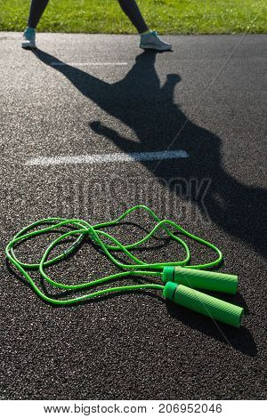 The Rope Lies On The Treadmill, And In The Background The Girl Stretches