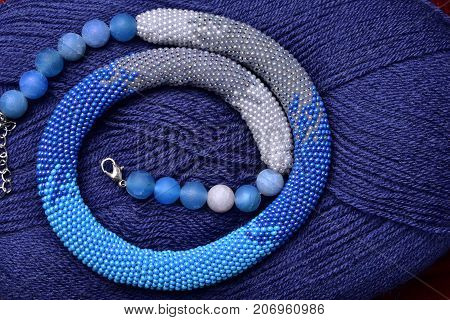 knitted flagellum from beads on a background of blue threads