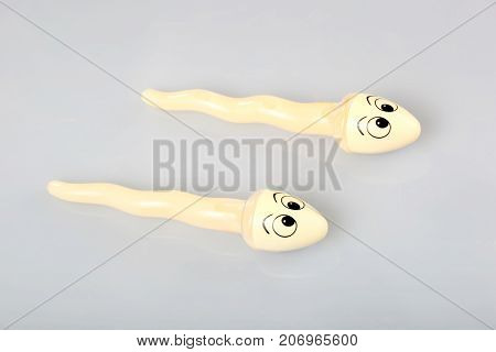 Two sperms (object) compete on blue background