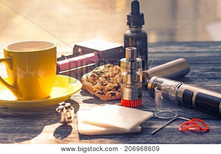 Still Life With Electronic Cigarette With Botle And Coffe On The Wooden Background