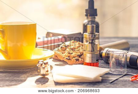 Still Life With Electronic Cigarette With Botle And Coffe On The Wooden Background