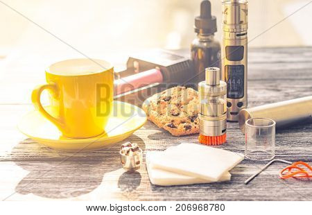 Still Life With Electronic Cigarette With Botle And Coffe On The Wooden Background