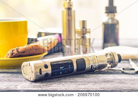 Still Life With Electronic Cigarette With Botle And Coffe On The Wooden Background