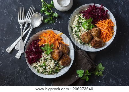 Fall buddha bowl. Bulgur spinach meatballs beets carrots - balanced healthy eating lunch. On a dark background top view. Comfort autumn winter food