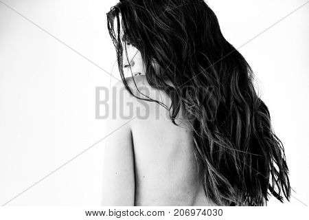 Sexy brunette girl in white swimsuit posing on a beach in black and white