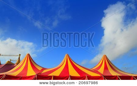 Cirkus telt rød orange og gule strippet mønster blå himmel