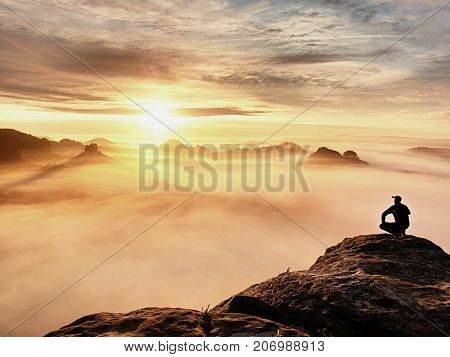 Tourist Sit On Peak Of Sandstone Rock And Watching Into Colorful Mist And Fog In  Morning Valley. Sa