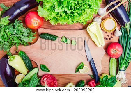Fresh organic vegetables - ingredients for salad and cutting board with knife and sliced cucumber. Diet, detox, vegetarian lifestyle concept . Selective focus.Space foc text