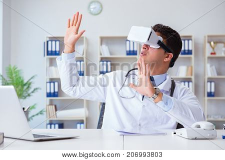 Young doctor with vr virtual reality headset working in the offi